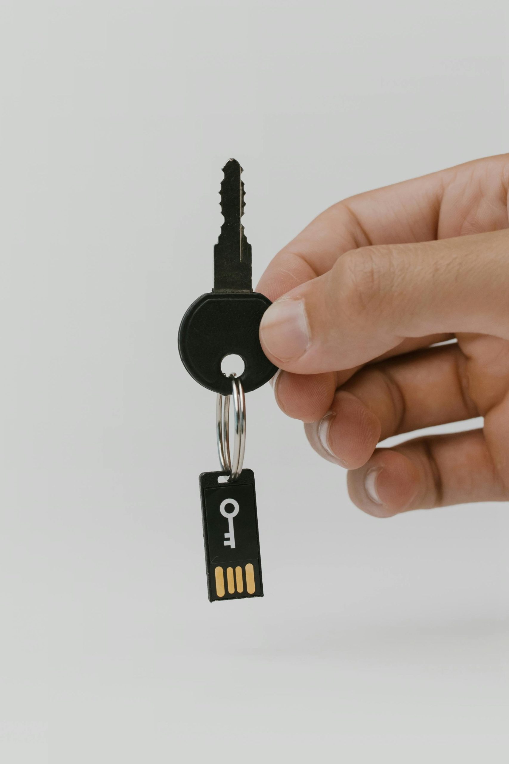 Close-up of a hand holding a key and USB with copyspace.